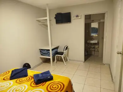 a room with a bed and a table and a bathroom at Hostal San Ignacio Monterrico in Lima