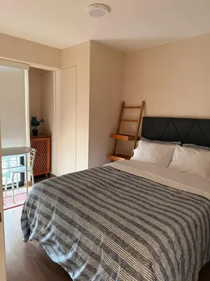 a bedroom with a large bed with a striped blanket at casahotel lof javier prado in Lima
