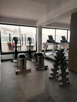 a gym with several treadmills and machines in a room at casahotel lof javier prado in Lima