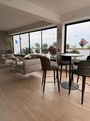 a living room with couches and a table and chairs at casahotel lof javier prado in Lima