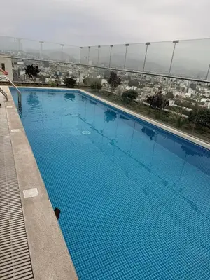 a large blue swimming pool on top of a building at casahotel lof javier prado in Lima