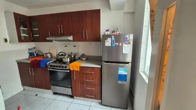a kitchen with a stainless steel refrigerator and wooden cabinets at Luna Room in Lima