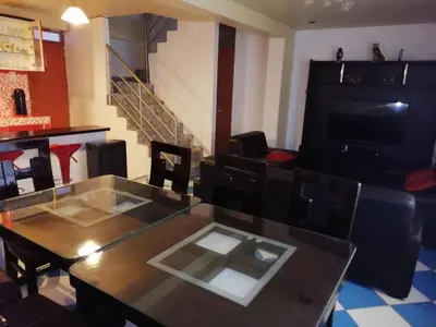 a living room with a table and a couch at Departamento turístico Rosaelena b&b 9 personas in Cusco