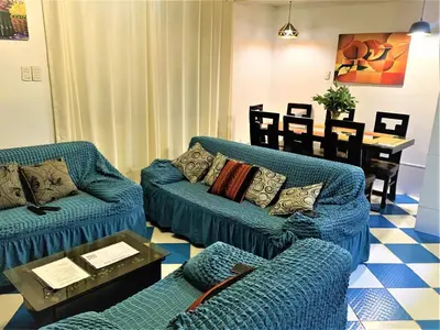 a living room with blue couches and a table at Departamento turístico Rosaelena b&b 9 personas in Cusco