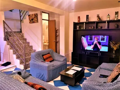 a living room with a couch and a tv at Departamento turístico Rosaelena b&b 9 personas in Cusco