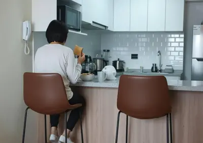 a woman sitting on a counter in a kitchen at E 24h Urban Comfort 1BR 302 in Lima