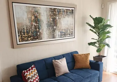 a blue couch in a living room with a painting at E 24h Urban Comfort 1BR 302 in Lima