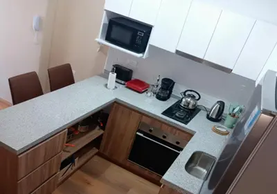 a small kitchen with a stove and a microwave at E 24h Urban Comfort 1BR 302 in Lima