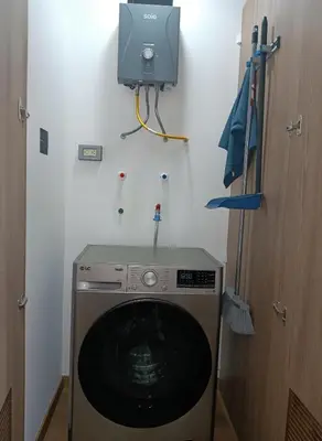 a washing machine in a room with a tv at E 24h Urban Comfort 1BR 302 in Lima
