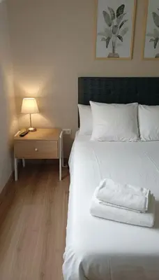 a bedroom with a white bed and a nightstand with a lamp at E Magdalena Costanera Access Wifi Pro 2B 204 in Lima