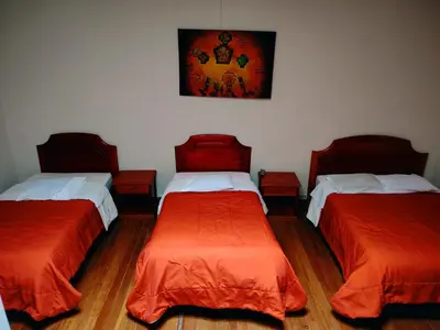 a room with two beds and a painting on the wall at Inkas Hotel Cusco in Cusco
