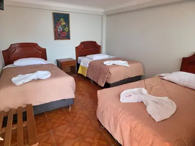 a room with three beds with towels on them at Inkas Hotel Cusco in Cusco