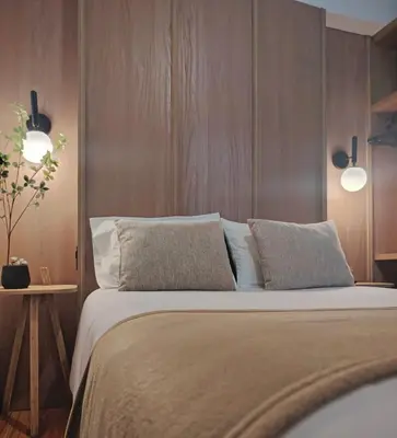 a bedroom with a large bed with a wooden wall at C&S Apartment Fierro in Cusco