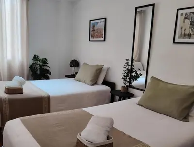 a hotel room with two beds and a mirror at C&S Apartment Fierro in Cusco