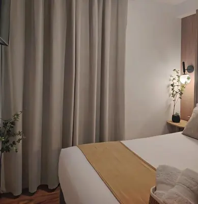 a bedroom with a bed and a window with curtains at C&S Apartment Fierro in Cusco