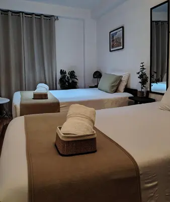 a bedroom with three beds with towels on them at C&S Apartment Fierro in Cusco