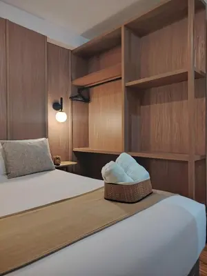 a bedroom with a bed with wooden walls and shelves at C&S Apartment Fierro in Cusco