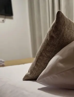 a brown pillow sitting on top of a bed at C&S Apartment Fierro in Cusco