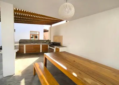 a living room with a wooden table and a kitchen at Casa de Campo Privada en Cieneguilla con Piscina y Cine in Cieneguilla