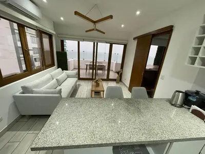 a living room with a table and a couch at Penthouse con Vista al Mar in Lima