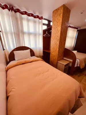 a hotel room with a bed and a chair at Pakari wasi inn in Cusco