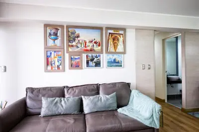 a living room with a brown couch and pictures on the wall at Upper Pardo Apartments in Lima