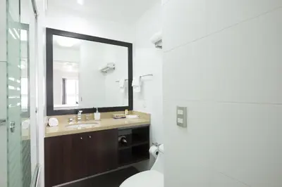 a bathroom with a sink and a mirror and a toilet at Upper Pardo Apartments in Lima
