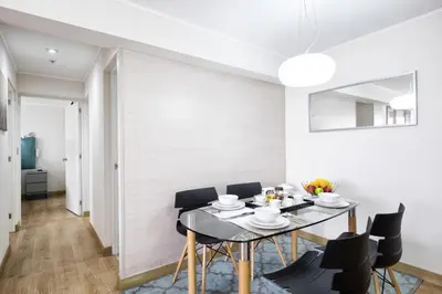 a dining room with a black table and black chairs at Upper Pardo Apartments in Lima