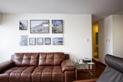 a living room with a brown leather couch at Guernica Apartments in Lima