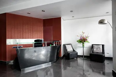 a lobby with two chairs and a bar with a table at Guernica Apartments in Lima