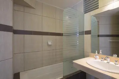 a bathroom with a sink and a glass shower at Guernica Apartments in Lima