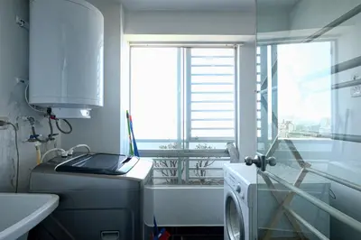 a laundry room with a washing machine and a window at Guernica Apartments in Lima