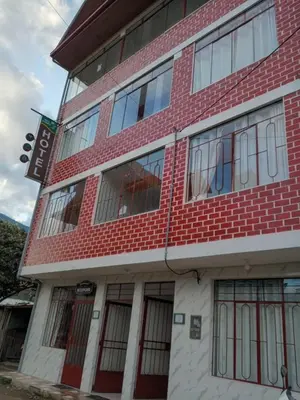 a red brick building with lots of windows at Hospedaje Bella Acuarela in Oxapampa