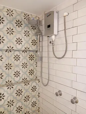 a shower in a bathroom with a tile wall at Apartamento Familiar con balcón y vista a la Ciudad, Centro in Cusco