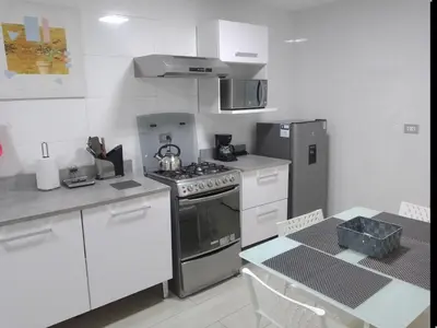 a kitchen with a stove and a table in it at 2-Bedroom Apartment in Magdalena del Mar in Lima