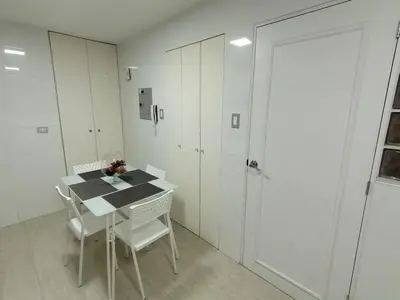 a white room with a table and chairs and a door at 2-Bedroom Apartment in Magdalena del Mar in Lima