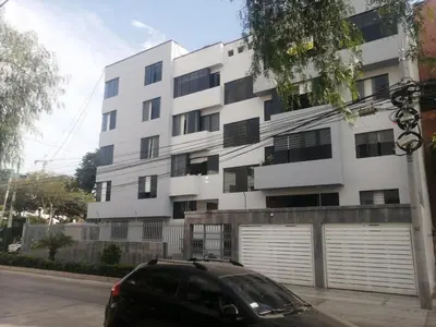 a black car parked in front of a white building at 2-Bedroom Apartment in Magdalena del Mar in Lima