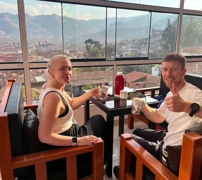 a man and a woman sitting at a table with thumbs up at Cusco and Rock in Cusco