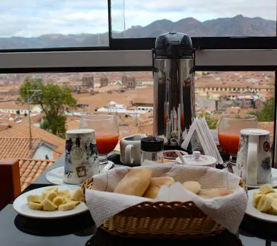 a table with a basket of bread and wine glasses at Cusco and Rock in Cusco