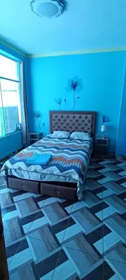 a bedroom with a bed in a blue room at Casa San Ramón in San Ramón