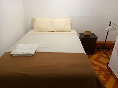 a bedroom with a bed with a brown and white blanket at Sumaq Tika in Cusco