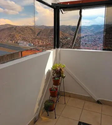 a balcony with potted plants and a view of a city at Sumaq Tika in Cusco