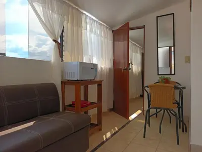 a living room with a couch and a table with a tv at Hanan Pacha in Cusco