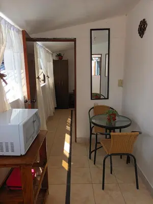 a living room with a microwave and a table at Hanan Pacha in Cusco