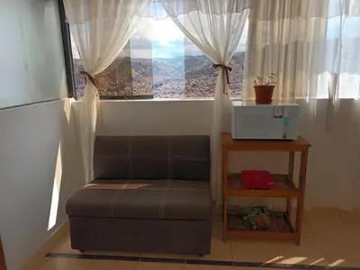 a couch sitting in a room with a window at Hanan Pacha in Cusco