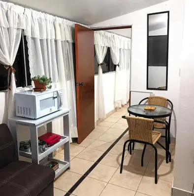 a living room with a table and a microwave at Hanan Pacha in Cusco