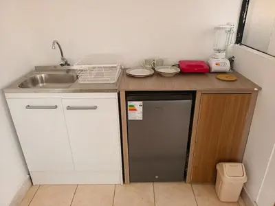 a small kitchen with a sink and a refrigerator at Hanan Pacha in Cusco