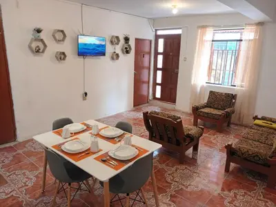 a dining room with a white table and chairs at Yuraq Wasicha in Cusco