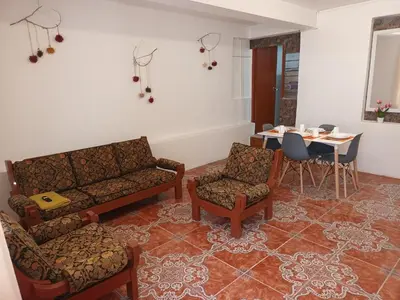 a living room with a couch and chairs and a table at Yuraq Wasicha in Cusco