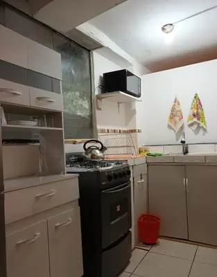 a kitchen with a stove top oven next to a sink at Yuraq Wasicha in Cusco